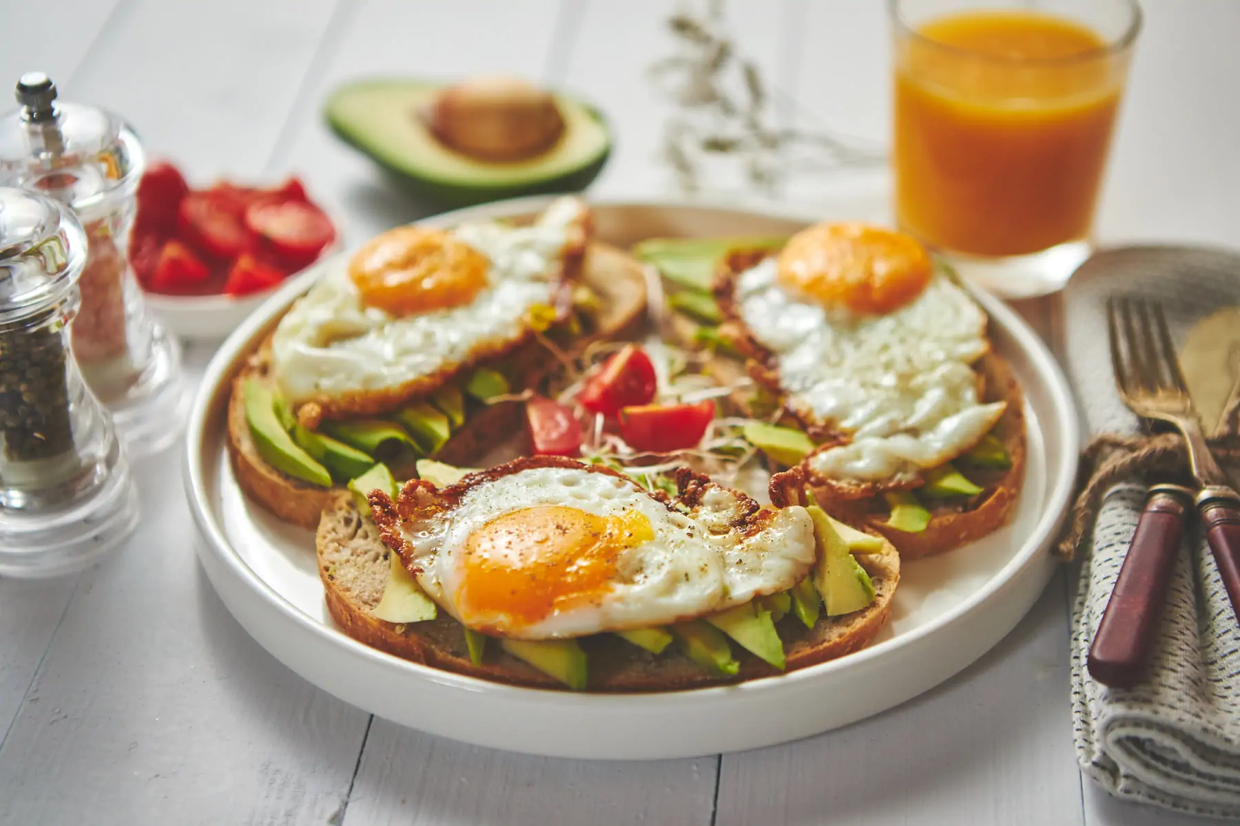 Avocado and fried egg toasts with orange juice