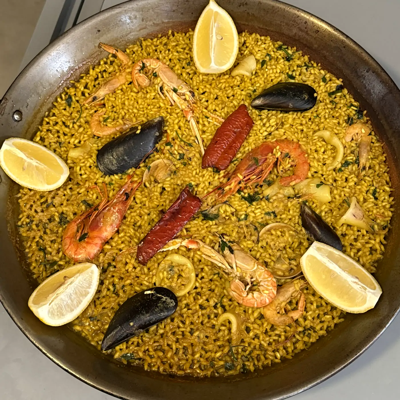 Rice with prawns, mussels and lemon in a paella pan